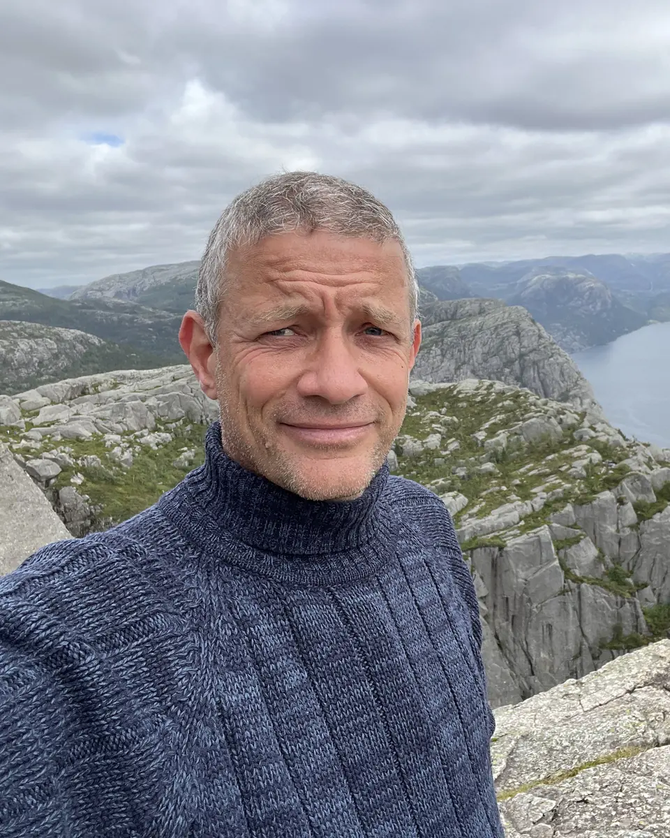 Morten Vesteraa på et fjeld med en fjord i baggrunden
